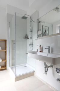 a white bathroom with a shower and a sink at Little Japan in Düsseldorf