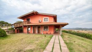 a small red house on a hill with a field at Tenuta dell'Argento Pool&Relax by Rentbeat in Civitavecchia +254 photos