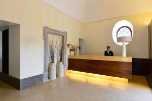 a man standing in a lobby with a mirror at Pousada Convento de Tavira in Tavira