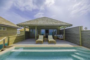 a house with a deck with chairs and a swimming pool at Nala Maldives by Jawakara in Lhaviyani Atoll