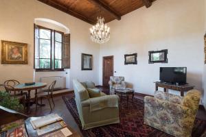 a living room with furniture and a chandelier at Relais Fattoria Valle in Panzano