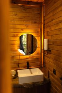 a white sink in a wooden bathroom with a mirror at Indra Village Hotel in Pazar