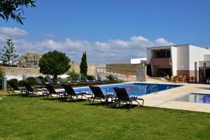 a group of chairs sitting next to a swimming pool at Pousada Convento de Tavira in Tavira