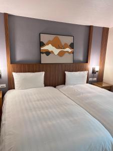 a bedroom with a large bed with white sheets at Chillax Inn 知樂愛河館 in Kaohsiung