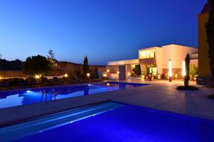 a villa with a swimming pool at night at Pousada Convento de Tavira in Tavira
