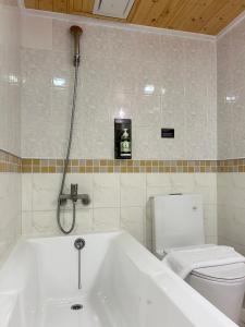 a bathroom with a white tub and a toilet at Chillax Inn 知樂愛河館 in Kaohsiung +54 photos