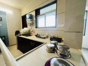 a kitchen with a sink and a counter top at Anahat Host All 2BHK Service Apartment in Nashik