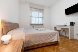 Un dormitorio con una cama, un escritorio y una mesa. en Locanda Enzina, en Bérgamo
