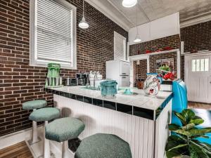a kitchen with a counter with stools in it at Guthrie's Historic Firehouse in Guthrie