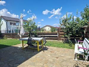 Un patio con una mesa y sillas y una sombrilla. en Jardin Maison - Therme- self access, en Baloteşti
