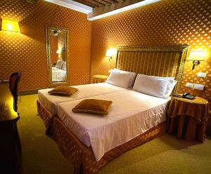 una stanza d'albergo con un letto e uno specchio di Hotel Corte Contarina a Venezia