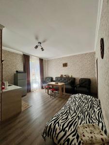 a bedroom with a zebra print bed and a living room at Achela's Guesthouse in Borjomi