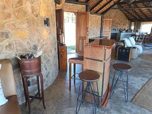 a room with stools and a bar in a stone wall at Sibani Lodge - Glamping Tents in Krugersdorp