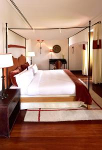 a bedroom with a large white bed and a desk at Pousada Convento de Tavira in Tavira