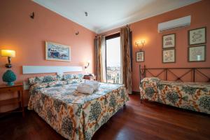a bedroom with a bed and a couch and a window at Hotel Vecchio Borgo in Palermo +44 photos