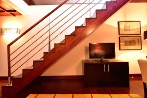 a living room with a staircase with a television at Pousada Convento de Tavira in Tavira