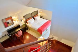 a bedroom with a bed and a desk in a room at Pousada Convento de Tavira in Tavira