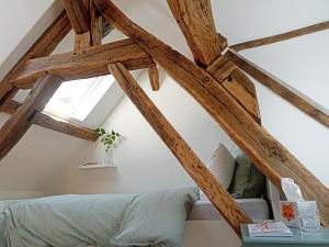 una camera da letto con soffitto in legno, letto e finestra di Maisonnette en centre ville a Breteuil-sur-Iton