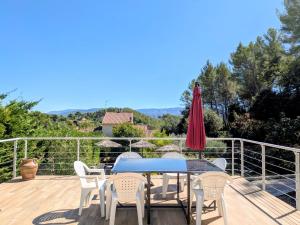 佩潘Le Soleil Levant - Villa familiale au coeur des sites incontournables的庭院配有桌椅和红色遮阳伞。