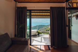 a living room with a couch and a large window at Sinsup villa Mountain View 1 in Ban Huai Khai