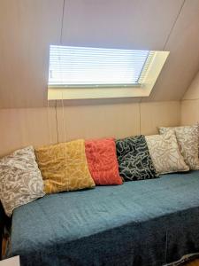 a row of pillows on a couch with a window at Tiny House ZEN 倉橋島 in Kure