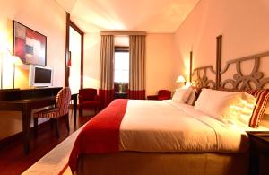 a hotel room with a bed and a desk at Pousada Convento de Tavira in Tavira