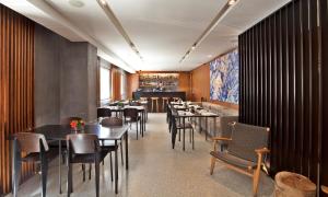 a restaurant with tables and chairs and a bar at Altis Prime Hotel in Lisbon
