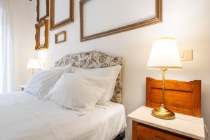 a bedroom with a bed with white pillows and a lamp at Panorama di mare suite via Cima Cagliari Centro in Cagliari