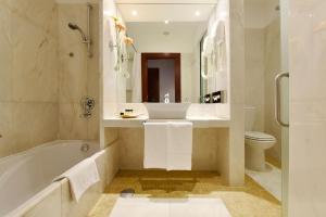 a bathroom with a tub and a sink and a toilet at Pousada Convento de Tavira in Tavira