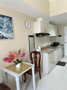 a kitchen with a table and a table and flowers on it at Sunvida Tower staycation unit 2503-2504 in Cebu City