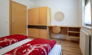 a bedroom with a bed and wooden cabinets at Gästehaus Kerber in Steeg