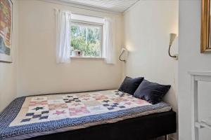 a bed in a room with a quilt on it at 30508-Odder-Dyngby-Havvej-42 in Odder