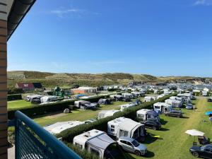 a group of camper vans parked in a field at Strandslag A233 in Ons Belang