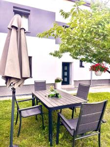 a wooden table with chairs and an umbrella at Großzügige 2-Etagen-Wohnung - Garten& Natur&See in Böhlen