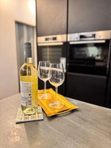 a bottle of wine and two wine glasses on a counter at Großzügige 2-Etagen-Wohnung - Garten& Natur&See in Böhlen