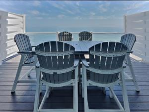 a table and chairs on a deck with the ocean at Put-in-Bay Waterfront Condo #104 in Put-in-Bay