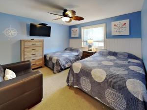a bedroom with two beds and a couch at Put-in-Bay Waterfront Condo #104 in Put-in-Bay