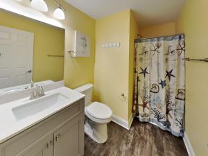 a bathroom with a toilet sink and a shower curtain at Put-in-Bay Waterfront Condo #104 in Put-in-Bay +18 photos