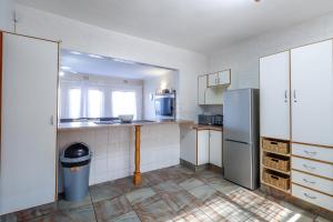 a kitchen with a refrigerator and a trash can at Carrick-A-Rede 7 in Margate