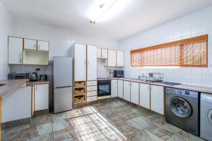 a kitchen with white cabinets and a washer and dryer at Carrick-A-Rede 7 in Margate +14 photos