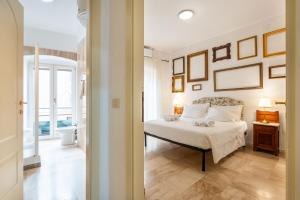 a bedroom with a white bed and pictures on the wall at Panorama di mare suite via Cima Cagliari Centro in Cagliari