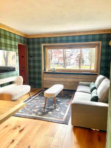 een woonkamer met een bank en een raam bij Cortina Center House in Cortina dʼAmpezzo