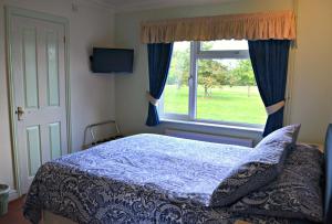 a bedroom with a bed and a window at Little Bullocks Farm in Takeley