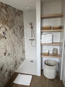a bathroom with a shower with a basket and towels at La Grange, Vendée, Nesmy in Nesmy