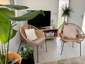 a living room with two chairs and a television at La Grange, Vendée, Nesmy in Nesmy