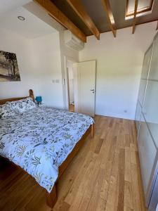 a bedroom with a bed and a wooden floor at Unkenhaus. Cosy, modern apartment, private parking in Lerwick