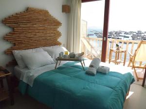 a bedroom with a bed and a balcony with a view at Bamboo Lodge Paracas in Paracas