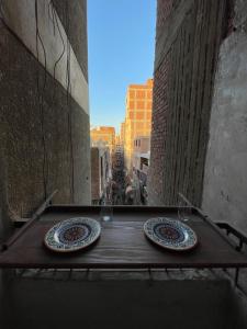 zwei Teller auf einem Holztisch in einer Gasse in der Unterkunft For Coffee Lovers in Kairo