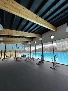 a gym with a row of exercise bikes in front of windows at Depto Frente a Laguna y Patio Privado in San Antonio
