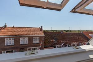 a view of the roofs from the balcony of a building at Welcome in - Onderaan de duinen, in het centrum - Langstraat 29 Zoutelande in Zoutelande